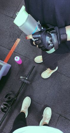 two people standing next to each other with gloves on and one person holding a water bottle