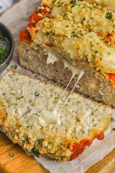 two slices of meatloaf with cheese and sauce on top, one slice cut in half