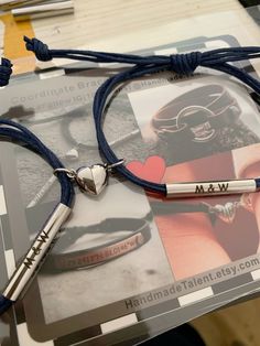 a couple of bracelets sitting on top of a table next to a book and pen