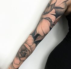 a woman's arm with black and white flowers on the left side of her arm