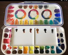 an open paint box filled with lots of different colored paints