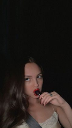 a woman with long hair is brushing her teeth