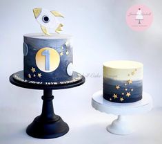 two cakes decorated with gold stars and blue frosting, one has a fish on top