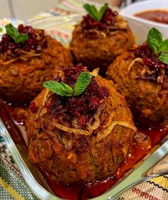 meatballs with cranberry sauce and mint garnish in a glass dish