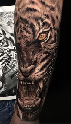 a man with a tiger tattoo on his arm next to a black and white photo