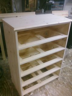 a wooden shelf with several shelves stacked on top of each other in the process of being built