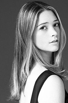 a black and white photo of a woman with shoulder length hair, wearing a tank top