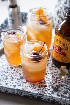 three jars filled with drinks sitting on top of a tray