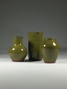 three green vases sitting next to each other