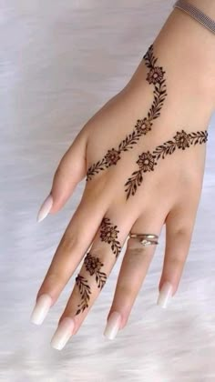 a woman's hand with henna tattoos on it