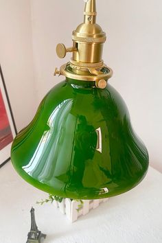 a green lamp sitting on top of a white table