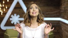 a woman standing in front of a wooden wall with snowflakes hanging from it