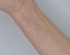 a small white flower tattoo on the wrist