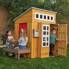 two children playing in a wooden play house