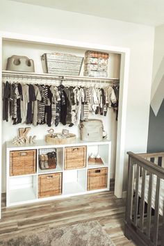 a baby's closet with clothes and baskets on the shelves next to a crib