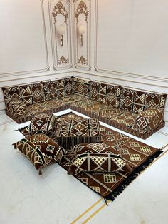 an ornately designed couch in the middle of a room with white walls and flooring