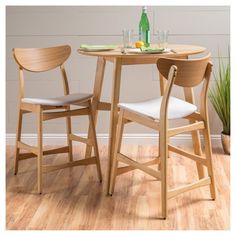 two wooden chairs sitting at a small table with bottles and glasses on top of it