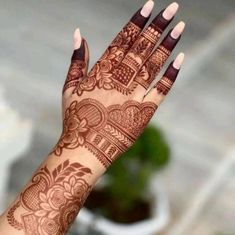 a woman's hand with henna tattoos on it