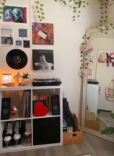 a room with various items and pictures on the wall, including a record player's desk