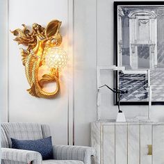 a living room with a chair, lamp and pictures on the wall