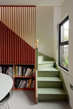 there is a book shelf next to the stairs