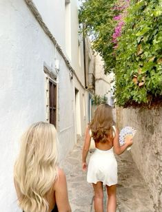 two women walking down a narrow alley way