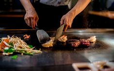 the chef is preparing food on the grill