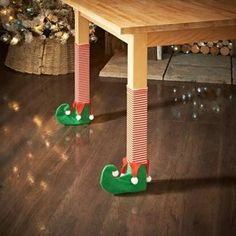 two green and red christmas stockings on legs under a table