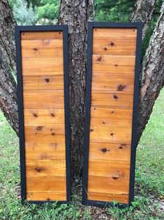 two large wooden panels sitting next to a tree