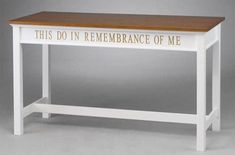 a white table with a wooden top that says, this do in remembrance of me