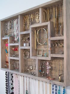 a wall mounted jewelry rack filled with lots of different necklaces and bracelets on it