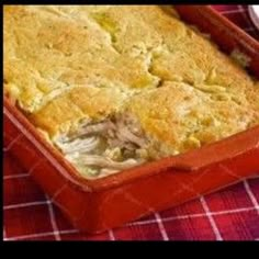 a casserole dish with chicken and cheese in it on a red checkered table cloth