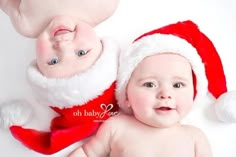 a baby is laying next to santa clause