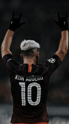 a man with his hands up in the air, wearing an orange and black uniform