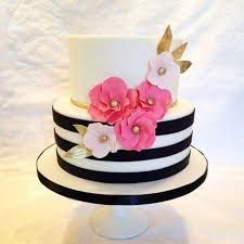 a white and black striped cake with pink flowers