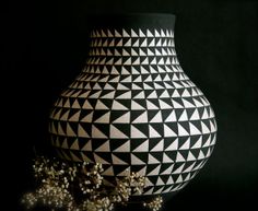 a black and white vase sitting on top of a table next to baby's breath flowers