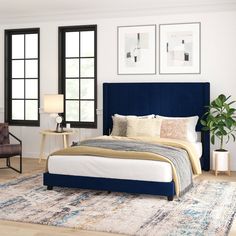 a bedroom with white walls and blue headboard