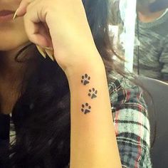 a woman with a dog paw tattoo on her left wrist and right hand behind her head