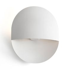 a white wall light that is on the side of a wall and has a circular shape