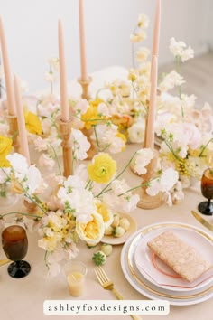 the table is set with flowers and candles