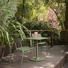 a green table and chairs on a deck