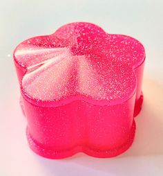 a pink box with glitter on it sitting on a white surface