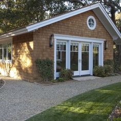 a small brown house with white trim and windows