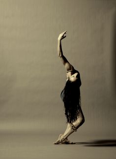 a woman is doing a handstand in the air with her arms stretched out