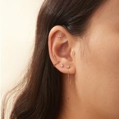 a close up of a woman's ear with two small earrings attached to it