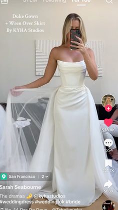 a woman in a white dress taking a selfie