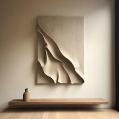 an abstract painting hangs on the wall next to a shelf