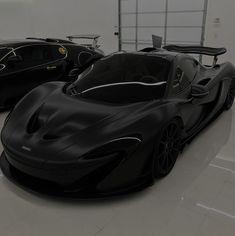 two black sports cars in a garage with no one around them or on the floor