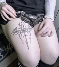 a woman's thigh with tattoos on her legs and the bottom part of her thighs