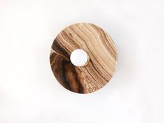 a wooden object with a white bowl on it's side and one piece of wood in the middle